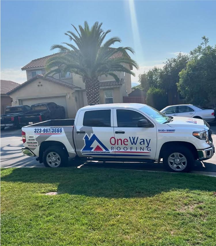 One Way Roofing Company's branded pickup truck displaying roofing services, contact info, and GAF certification, parked on a street in the Inland Empire.