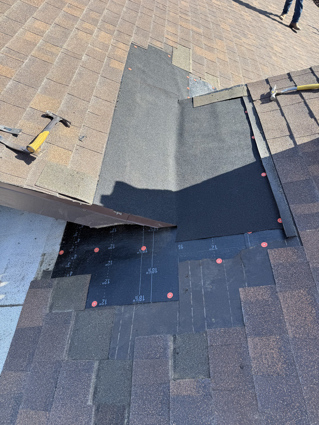 asphalt roof leak repair in progress