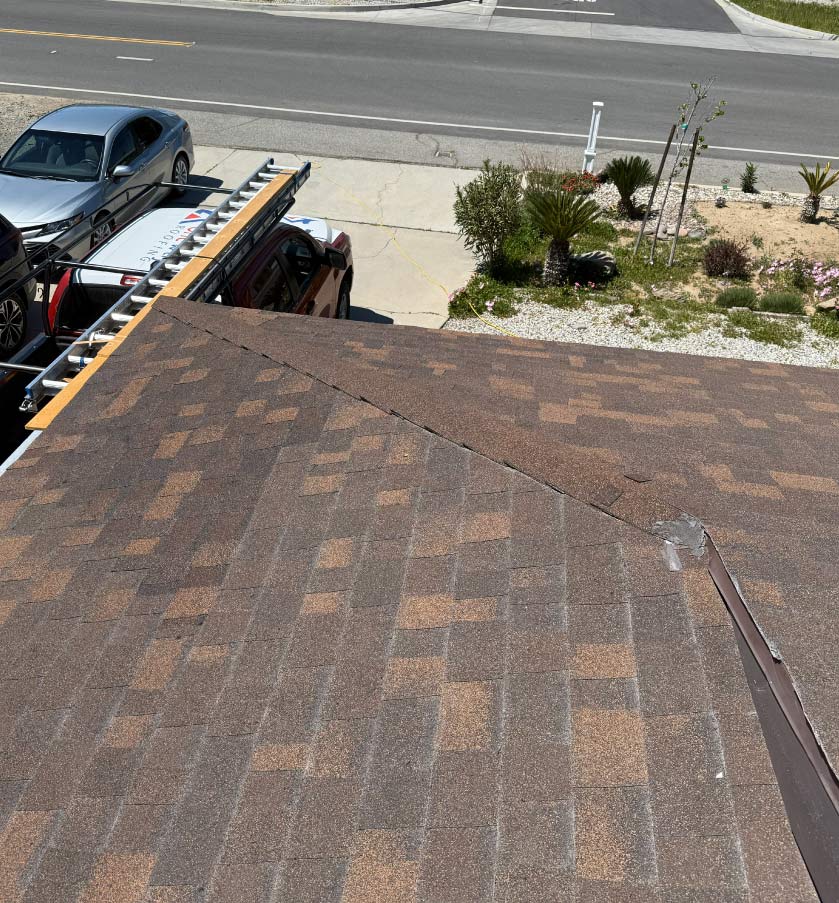 Newly completed residential roof featuring multi-tone brown architectural asphalt shingles and clean valley installation.