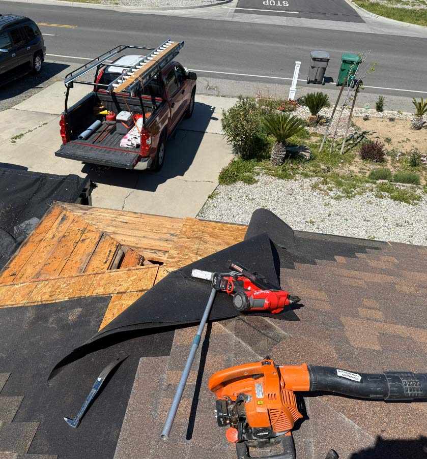 Roof leak repair process involving the removal of damaged shingles and replacement of rotted wood decking.